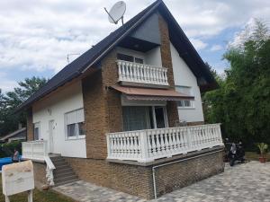 a house with a balcony and a satellite at Wolf Vendégház in Balatonkeresztúr