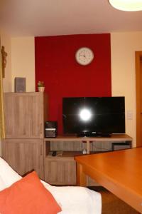 阿爾高地區旺根的住宿－Ferienwohnung Kitzelmann，配有电视和带时钟的红色墙壁的客房