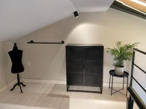 a black cabinet in a white room with a plant at Hacienda Soto-Hego Haizea in Chiclana de la Frontera