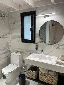 a bathroom with a toilet and a sink and a mirror at Hacienda Soto-Hego Haizea in Chiclana de la Frontera
