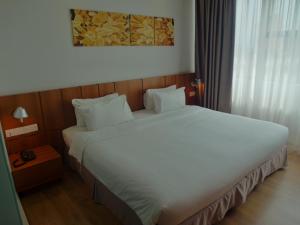 a bedroom with a large white bed in a room at French Hotel in Ipoh