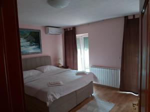 a bedroom with a white bed and a window at Vila Jasmina in Bihać
