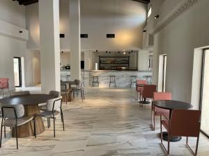 a room with tables and chairs and a bar at Hacienda Soto-Hego Haizea in Chiclana de la Frontera