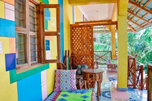 een kamer met ramen en een tafel en stoelen bij Coccobello Zanzibar in Nungwi