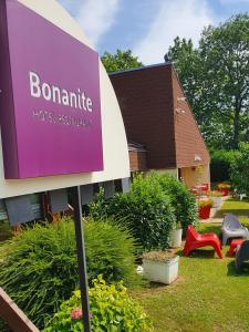 un cartello di fronte a un edificio con giardino di Hotel Bonanite a Villers-Cotterêts