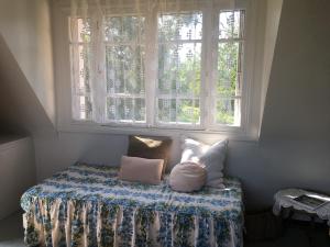 a bed sitting under a window with pillows on it at Maison BelleMondo in Criel-sur-Mer