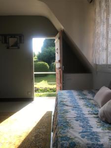 a bedroom with a bed and an open door at Maison BelleMondo in Criel-sur-Mer
