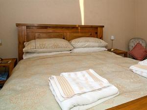 a large bed with two white towels on it at Hebridean Guest House in Stornoway