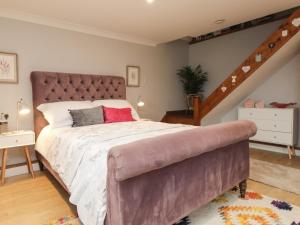 um quarto com uma cama grande e uma escada em Ditsys Den em Tonbridge