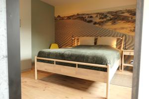 een slaapkamer met een bed en een schilderij aan de muur bij Appartement ' Het Zilte'. in Yerseke