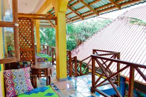 een kamer met een balkon met een tafel en stoelen bij Coccobello Zanzibar in Nungwi
