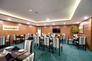 拉合爾的住宿－Hotel One Gulberg, Lahore，餐厅设有桌椅和平面电视。