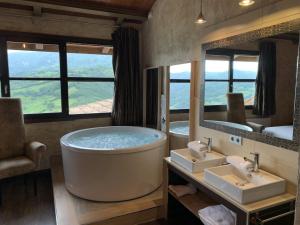 a bathroom with a tub and two sinks and a mirror at LA ALDEA SOÑADA in Oviedo +74 photos