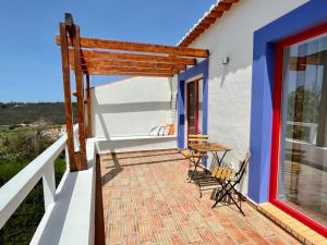a balcony of a house with a table and chairs at Casas Do Moinho - Turismo De Aldeia in Odeceixe