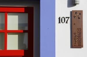 um edifício com uma porta e um relógio de lado em Casas Do Moinho - Turismo De Aldeia em Odeceixe