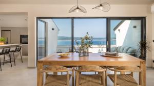 a kitchen and dining room with a wooden table and chairs at Apartments Villa Frankola with swimming pool in Crikvenica