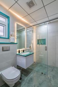 a bathroom with a toilet and a glass shower at SKYLA Serviced Apartments & Suites, Hi-Tech City in Hyderabad