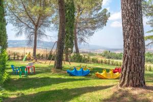 a picnic table and chairs in a park at Hotel Palazzuolo in San Quirico dʼOrcia
