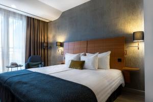 a hotel room with a large bed with a blue blanket at Scandic Simonkenttä in Helsinki