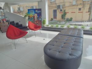 two chairs and a leather ottoman in a room at French Hotel in Ipoh
