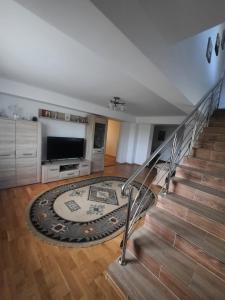 a living room with a staircase and a television at Pensiunea Deny şi Dany in Ribiţa