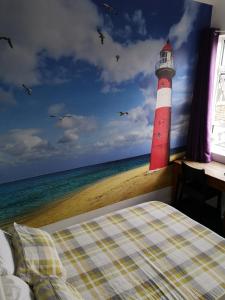 a bedroom with a red and white lighthouse next to the ocean at Igloo Hybrid in Nottingham
