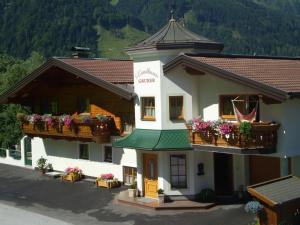 a building with two balconies and flowers on it at Landhaus Gruber Sommer in Sankt Johann im Pongau
