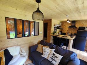 a living room with a couch and a kitchen at Au Pré de Mukky in Andenne
