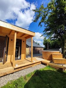 eine Holzhütte mit einer Veranda und einer Terrasse in der Unterkunft Au Pré de Mukky in Andenne