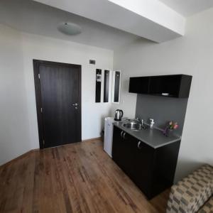 a small kitchen with a sink and a black door at Hotel Radi in Sapareva Banya