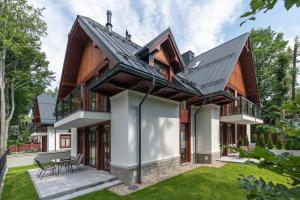 a contemporary house with a metal roof at Apartamenty Park Residence by Nosalowy in Zakopane