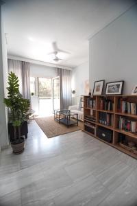 uma sala de estar com um sofá e uma estante de livros em Your cozy downtown home - Apartment em Lárissa