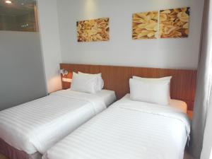 two beds sitting next to each other in a room at French Hotel in Ipoh