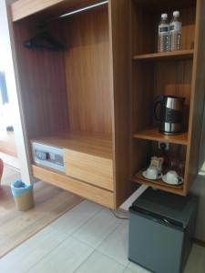 a cupboard with a microwave and a coffee maker at French Hotel in Ipoh