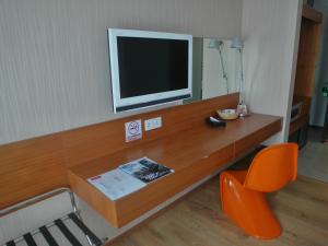 a room with a desk with a television and a chair at French Hotel in Ipoh