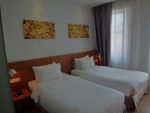 a hotel room with two beds and a window at French Hotel in Ipoh