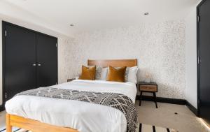 a bedroom with a large bed with a wooden headboard at The Wapping Wharf - Modern & Bright 2BDR Flat on the Thames with Parking in London