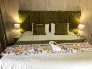 a bedroom with a bed and two lamps and avertisement at The Guesthouse Klerksdorp in Klerksdorp