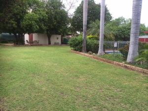 un patio con palmeras y una valla en Copper Gate Motel, en Mount Isa