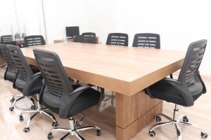 una sala de conferencias con una mesa y sillas de madera en TS HOTEL, en Porteirinha