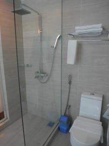 a bathroom with a glass shower with a toilet at French Hotel in Ipoh