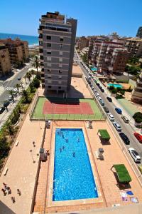 a swimming pool in front of a building with a hotel at Apartamento Arenales in Arenales del Sol