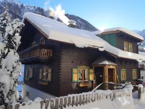 domek z bali i śniegiem na dachu w obiekcie St Anton 365 w mieście Sankt Anton am Arlberg