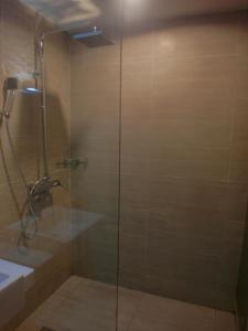 a shower with a glass door next to a sink at French Hotel in Ipoh