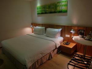 a bedroom with a bed and a table and a chair at French Hotel in Ipoh
