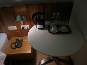 a table with a coffee maker on top of it at French Hotel in Ipoh