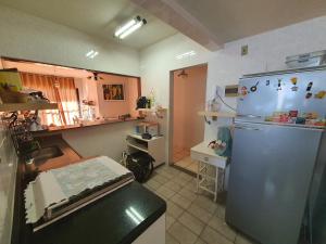 a kitchen with a blue refrigerator in a kitchen at Apartamento quadra praia com vista mar in Guarapari
