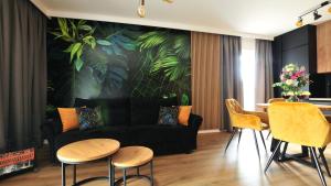 a living room with a couch and a table and chairs at Residence Polanica z sauną, Sun & Snow in Polanica-Zdrój