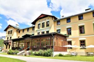 un grande edificio giallo con tavoli di fronte di Gasthof Elisabeth a Bad Aussee