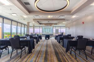 a restaurant with black tables and chairs and windows at Holiday Inn Miami International Airport by IHG in Miami +37 photos